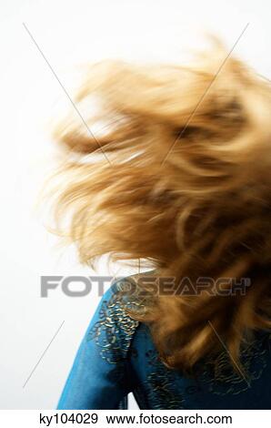Stock Photo - Young woman with blond hair, view from the back, blurred motion, close up (studio). Fotosearch
