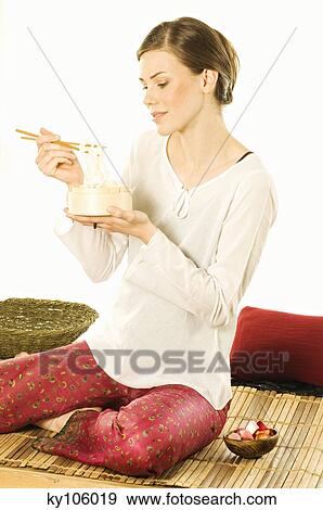 Stock Photo - Woman eating chinese pasta. Fotosearch