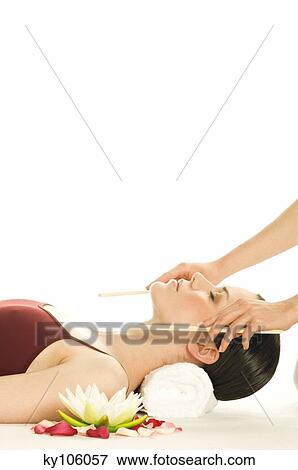Stock Photo - Woman having head massaged, water lily. Fotosearch