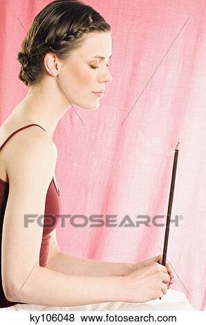 Stock Photo - Woman holding incense stick. Fotosearch