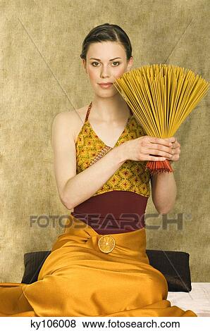 Stock Photo - Woman holding incense sticks. Fotosearch