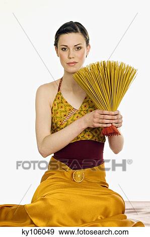 Stock Photo - Woman holding incense sticks. Fotosearch