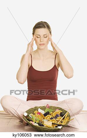 Woman sitting cross-legged, relaxation accessories in dish in front of her, shut eyes View Large Photo Image Stock Image - Woman sitting cross-legged, relaxation accessories in dish in front of her, shut eyes. Fotosearch