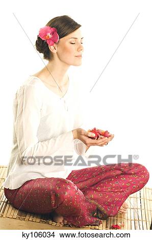 Young woman holding flower petals in a little dish, shut eyes View Large Photo Image Picture - Young woman holding flower petals in a little dish, shut eyes. Fotosearch
