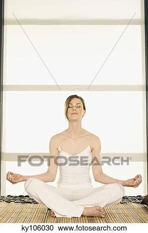 Young woman sitting cross-legged, yoga attitude, shut eyes View Large Photo Image Stock Image - Young woman sitting cross-legged, yoga attitude, shut eyes. Fotosearch