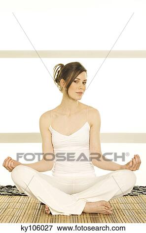 Young woman sitting cross-legged, yoga attitude, looking at the camera View Large Photo Image Stock Photo - Young woman sitting cross-legged, yoga attitude, looking at the camera. Fotosearch