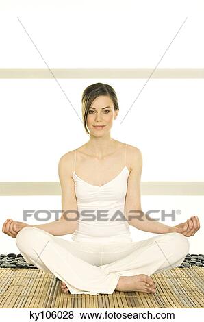 Young woman sitting cross-legged, yoga attitude, looking at the camera View Large Photo Image Stock Photo - Young woman sitting cross-legged, yoga attitude, looking at the camera. Fotosearch