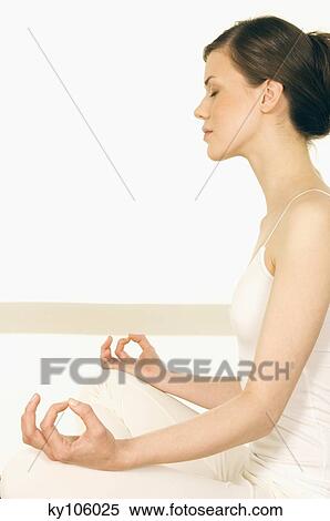 Stock Photography - Young woman sitting in profile, yoga attitude. Fotosearch