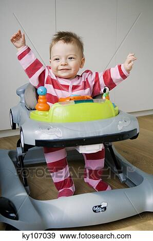 Baby in a baby-walker, interior View Large Photo Image Stock Photo - Baby in a baby-walker, interior. Fotosearch