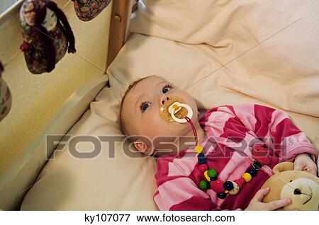 Baby in bed with comforter View Large Photo Image Stock Photo - Baby in bed with comforter. Fotosearch