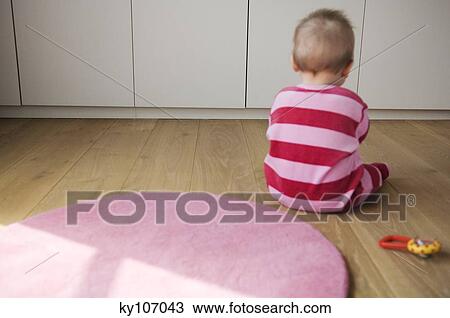 Baby playing siiting on the floor, view from the back View Large Photo Image Stock Image - Baby playing siiting on the floor, view from the back. Fotosearch