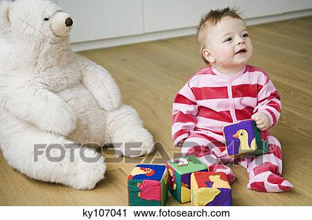Baby playing, sitting on floor View Large Photo Image Stock Image - Baby playing, sitting on floor. Fotosearch