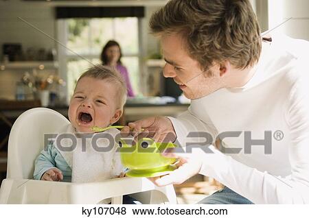 Father feeding her baby, crying View Large Photo Image Stock Photo - Father feeding her baby, crying. Fotosearch