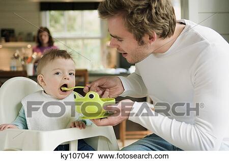 Father feeding her baby View Large Photo Image Stock Photo - Father feeding her baby. Fotosearch