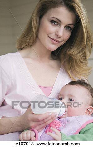 Stock Image - Mother bootle-feeding her baby. Fotosearch