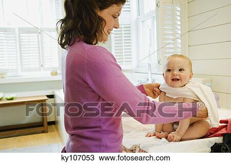 Mother dressing her baby View Large Photo Image Stock Image - Mother dressing her baby. Fotosearch