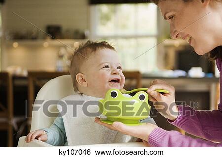 Stock Photograph - Mother feeding her baby. Fotosearch