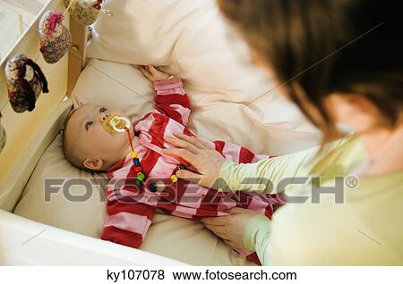 Mother fondling her baby in bed with comforter View Large Photo Image Stock Photo - Mother fondling her baby in bed with comforter. Fotosearch