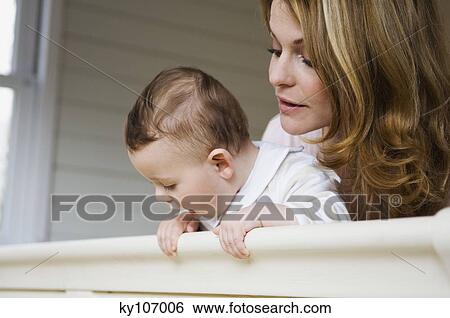 Woman and baby looking out of the window View Large Photo Image Stock Photograph - Woman and baby looking out of the window. Fotosearch