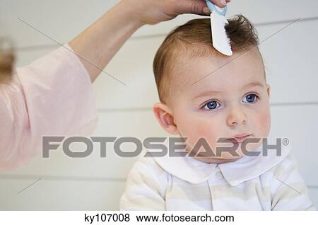 Woman combing her baby View Large Photo Image Stock Photo - Woman combing her baby. Fotosearch