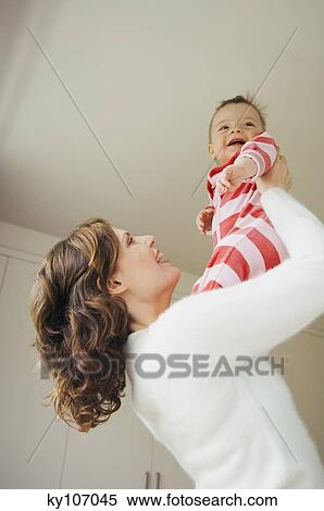 Woman holding her baby, smiling View Large Photo Image Stock Photography - Woman holding her baby, smiling. Fotosearch