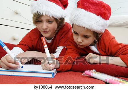 2 boys disguised as Santa Claus, writing View Large Photo Image Picture - 2 boys disguised as Santa Claus, writing. Fotosearch