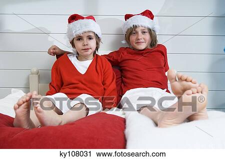 2 boys on bed, disguised as Santa Claus View Large Photo Image Stock Image - 2 boys on bed, disguised as Santa Claus. Fotosearch