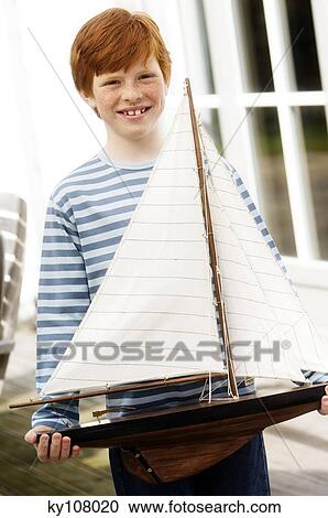 Boy holding a model boat View Large Photo Image Stock Image - Boy holding a model boat. Fotosearch
