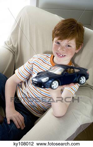 Stock Image - Little boy holding car toy. Fotosearch