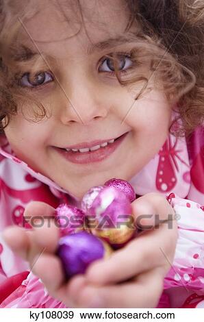 Little girl holding Easter eggs View Large Photo Image Stock Photo - Little girl holding Easter eggs. Fotosearch