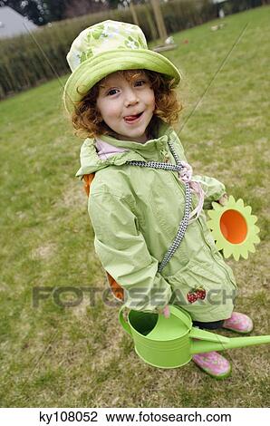 Little girl in garden holding watering can View Large Photo Image Stock Image - Little girl in garden holding watering can. Fotosearch
