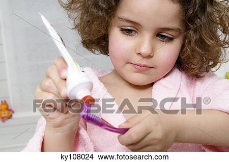 Little girl squeezing toothpaste onto toothbrush View Large Photo Image Picture - Little girl squeezing toothpaste onto toothbrush. Fotosearch