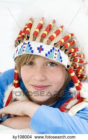 Picture - Portrait of a young boy looking at the camera, with indian headdress. Fotosearch