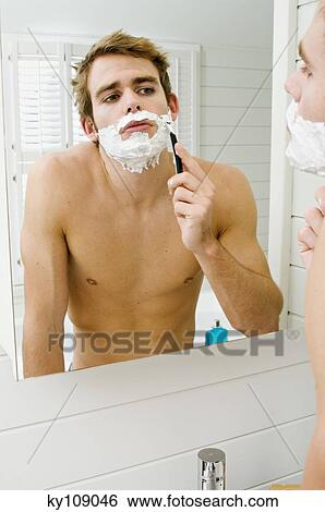 Barechested man shaving in front of bathroom mirror View Large Photo Image Stock Photograph - Barechested man shaving in front of bathroom mirror. Fotosearch