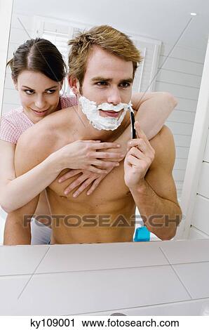 Couple embracing in bathroom, barechested man shaving in front of mirror View Large Photo Image Stock Image - Couple embracing in bathroom, barechested man shaving in front of mirror. Fotosearch