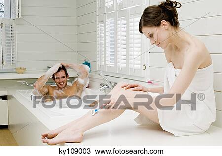 Couple in bathroom, man having a bath and woman wrapped in a towel shaving her legs View Large Photo Image Stock Image - Couple in bathroom, man having a bath and woman wrapped in a towel shaving her legs. Fotosearch