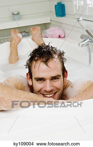 Young man having a bath, smiling for the camera View Large Photo Image Picture - Young man having a bath, smiling for the camera. Fotosearch