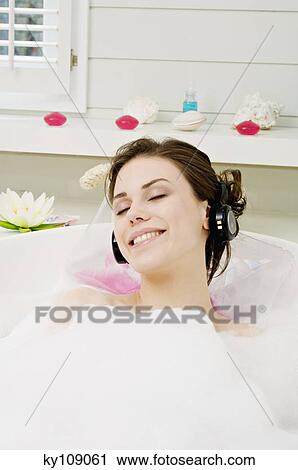 Young woman having a bath, wearing headphones View Large Photo Image Stock Image - Young woman having a bath, wearing headphones. Fotosearch