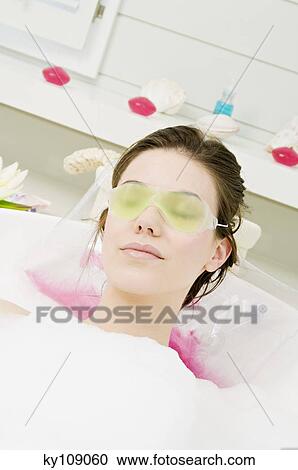 Young woman having a bath, with a gel eye mask View Large Photo Image Stock Image - Young woman having a bath, with a gel eye mask. Fotosearch