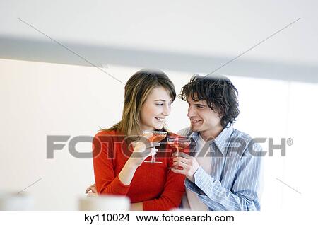 Couple clinking champagne glasses, looking at each other View Large Photo Image Picture - Couple clinking champagne glasses, looking at each other. Fotosearch