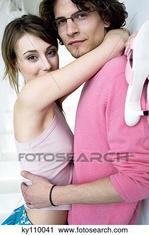 Stock Image - Couple embracing, looking at the camera. Fotosearch