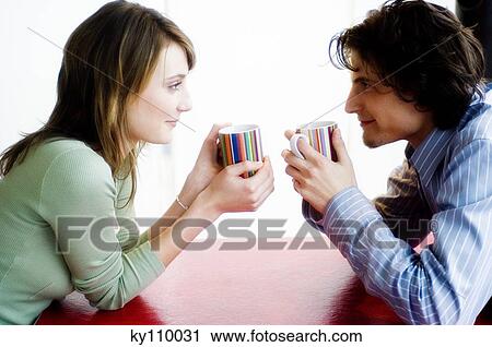 Couple holding cups, face to face, looking at each other, side view View Large Photo Image Stock Image - Couple holding cups, face to face, looking at each other, side view. Fotosearch
