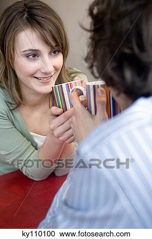 Couple holding cups, face to face, looking at each other View Large Photo Image Stock Image - Couple holding cups, face to face, looking at each other. Fotosearch