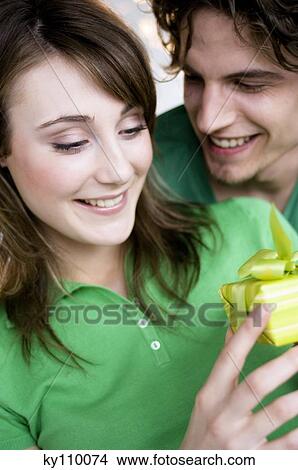 Man giving present to smiling woman View Large Photo Image Picture - Man giving present to smiling woman. Fotosearch