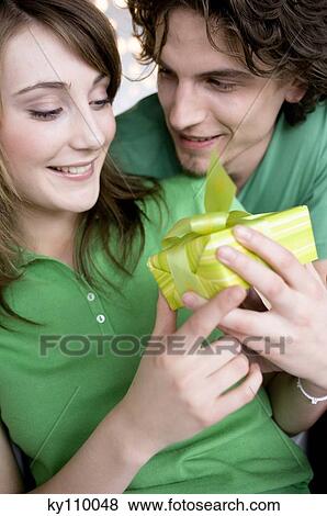 Man giving present to smiling woman View Large Photo Image Stock Photo - Man giving present to smiling woman. Fotosearch