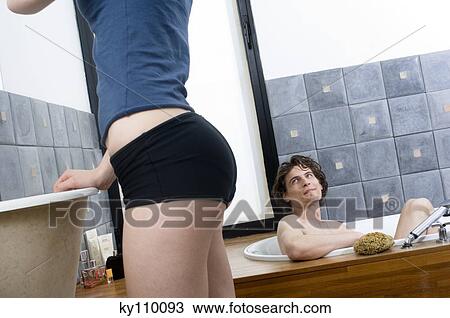 Man having a bath looking at woman standing View Large Photo Image Stock Image - Man having a bath looking at woman standing. Fotosearch
