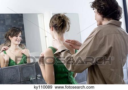 Man helping woman get dressed in front of bathroom mirror View Large Photo Image Stock Photo - Man helping woman get dressed in front of bathroom mirror. Fotosearch