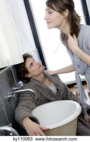 Man in bathrobe sitting, looking at woman standing in front of bathroom mirror View Large Photo Image Stock Image - Man in bathrobe sitting, looking at woman standing in front of bathroom mirror. Fotosearch
