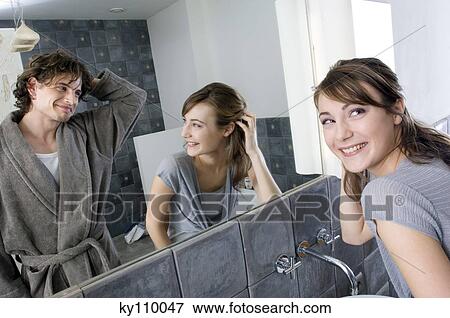 Smiling couple in front of bathroom mirror View Large Photo Image Stock Photo - Smiling couple in front of bathroom mirror. Fotosearch