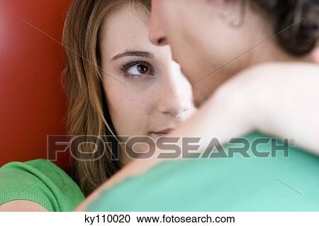 Stock Image - Young couple embracing, close-up. Fotosearch